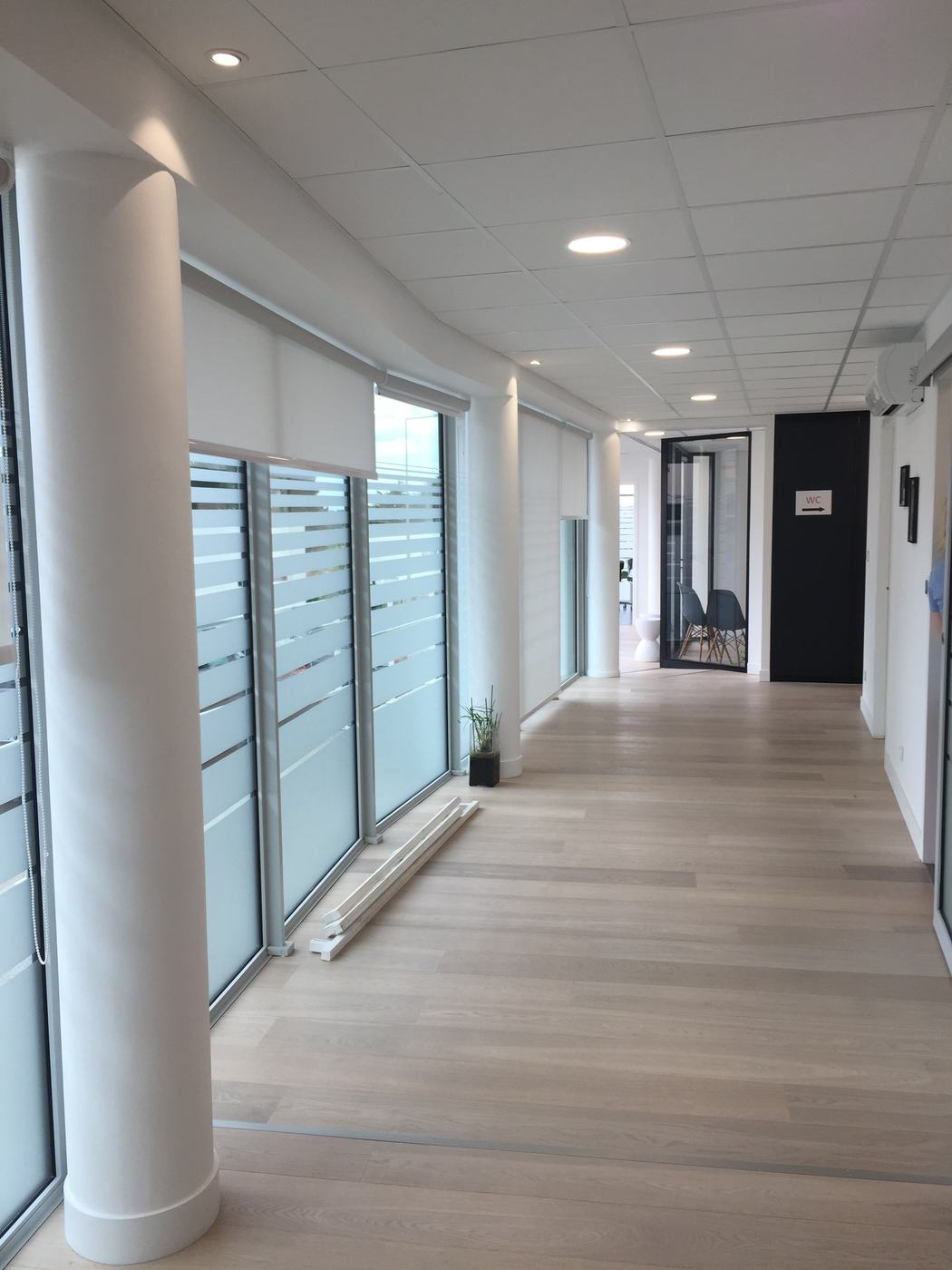 Stores enrouleurs intérieurs dans un couloir vitré — JLR Menuiseries Angers